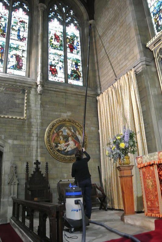 Fotografía de acción de SkyVac®️: limpieza de techos altos en una iglesia